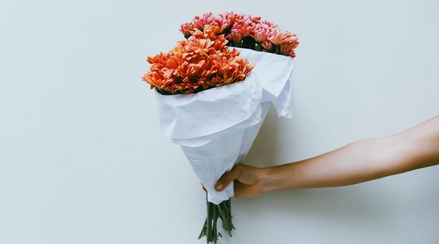 main tendant un bouquet de fleurs roses